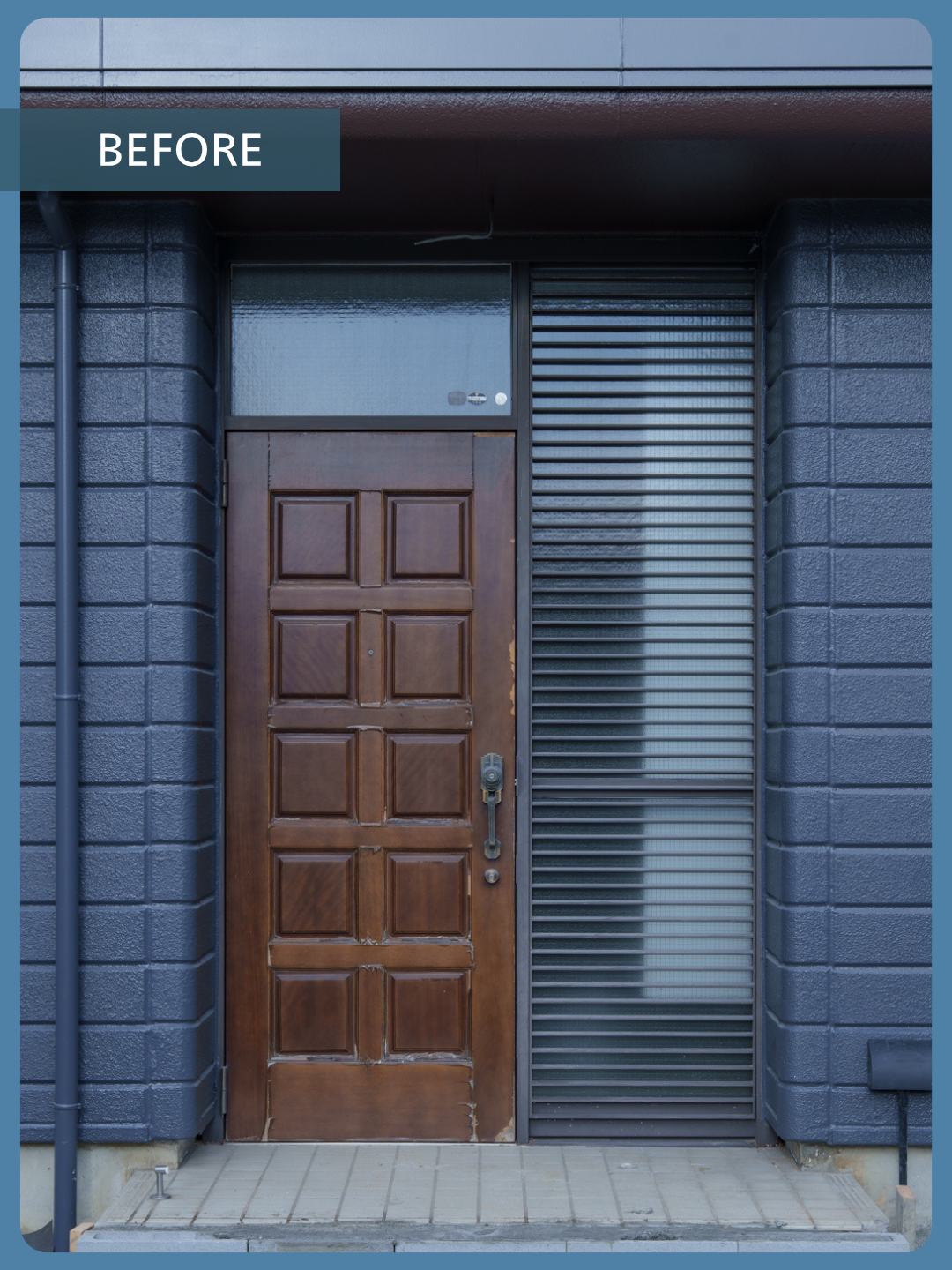 Wooden front door with rectangular panels next to a glass window with horizontal blinds, set in a blue-gray brick facade.